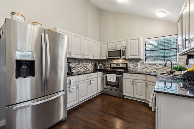 400 Crooked Ln, Mesquite, TX 75149 - kitchen with appliances with stainless steel finishes, backsplash, a sink, dark wood-style flooring, and high vaulted ceiling