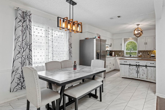 1426 Northridge Dr, Carrollton, TX 75006 - dining area with a chandelier, a textured ceiling, and light marble finish floors