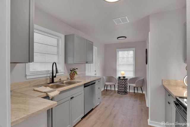 kitchen with electric range oven, a sink, dishwasher, light wood-type flooring, and baseboards