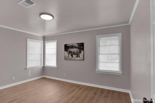 unfurnished room with light wood finished floors, baseboards, and crown molding