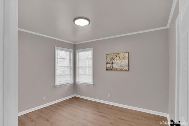 empty room with wood finished floors, ornamental molding, and baseboards