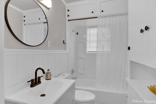 bathroom featuring toilet, bathtub / shower combination, a wainscoted wall, and vanity