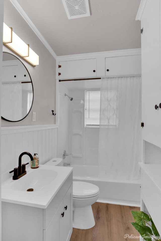 bathroom with washtub / shower combination, wood finished floors, toilet, a wainscoted wall, and vanity