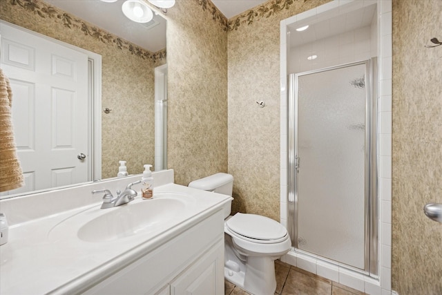 bathroom with tile patterned floors, a stall shower, toilet, and vanity