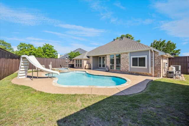 view of pool with a water slide, a patio area, central AC, and a pool with connected hot tub