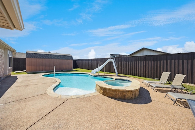 view of pool with a water slide, a fenced backyard, a patio, and a shed