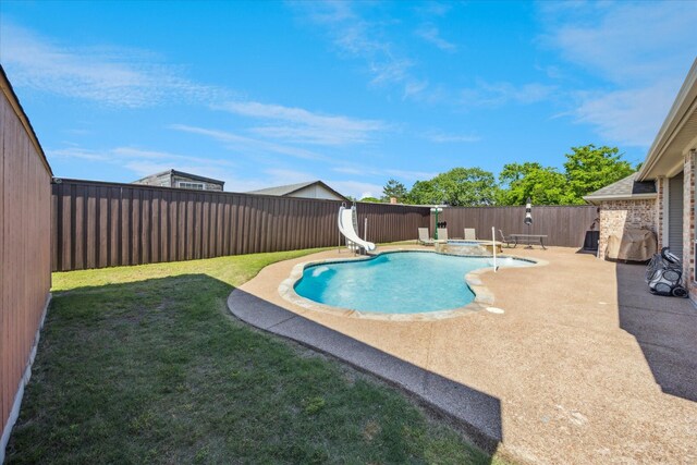 view of swimming pool with a water slide, a patio area, and a pool with connected hot tub