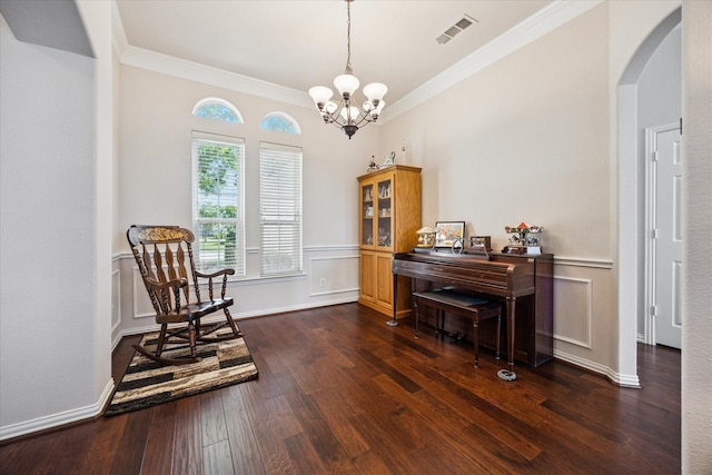 sitting room featuring arched walkways, crown molding, a chandelier, dark wood-style floors, and wainscoting