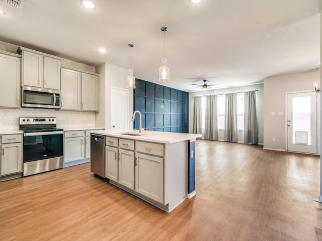 3305 Brentwood Cv, Forney, TX 75126 - kitchen featuring appliances with stainless steel finishes, a sink, light wood-type flooring, healthy amount of natural light, and recessed lighting