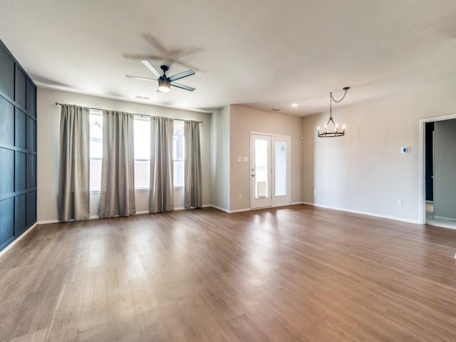 3305 Brentwood Cv, Forney, TX 75126 - unfurnished living room featuring ceiling fan, a chandelier, wood finished floors, and baseboards