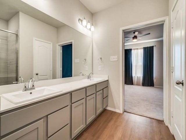 3305 Brentwood Cv, Forney, TX 75126 - bathroom featuring double vanity, ceiling fan, a tile shower, wood finished floors, and baseboards