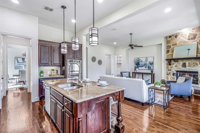 901 Clear Water Dr, Allen, TX 75013 - kitchen with open floor plan, dark wood finished floors, light stone countertops, a sink, and hanging light fixtures