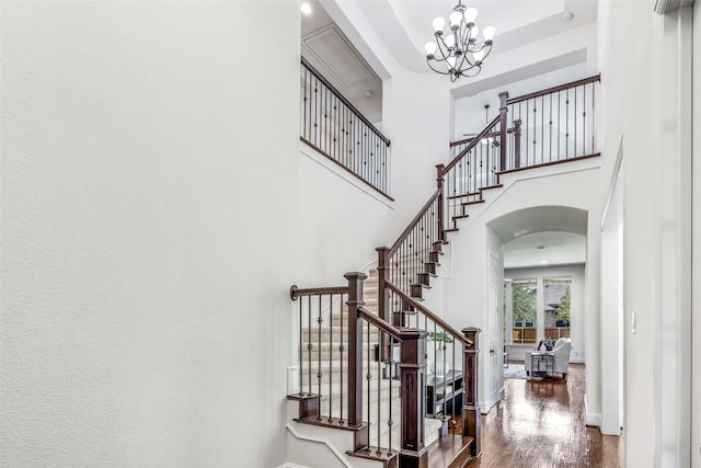 901 Clear Water Dr, Allen, TX 75013 - foyer featuring arched walkways, wood finished floors, a chandelier, a high ceiling, and stairway