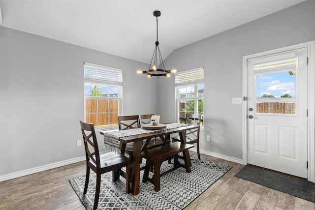 2104 Shane Ave, Fort Worth, TX 76134 - dining area featuring vaulted ceiling, a chandelier, healthy amount of natural light, light wood finished floors, and baseboards