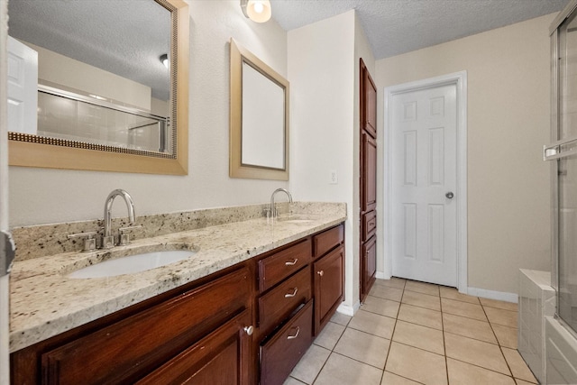 1204 Calico Ln Unit 720, Arlington, TX 76011 - bathroom with a shower with shower door, double vanity, tile patterned flooring, and a textured ceiling