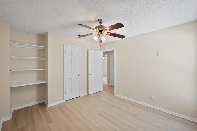 1204 Calico Ln Unit 720, Arlington, TX 76011 - unfurnished bedroom with light wood-style floors, a textured ceiling, a ceiling fan, and a closet