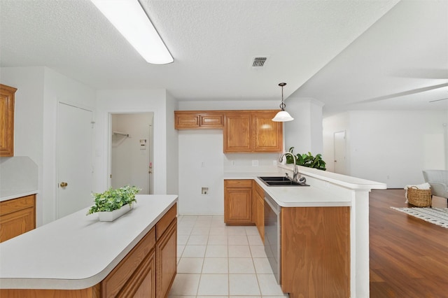 218 Whispering Dell Ln, Weatherford, TX 76085 - kitchen with open floor plan, a sink, brown cabinetry, light countertops, and a textured ceiling