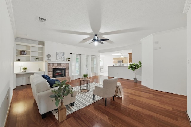 218 Whispering Dell Ln, Weatherford, TX 76085 - living area featuring a brick fireplace, wood finished floors, ceiling fan, crown molding, and a textured ceiling