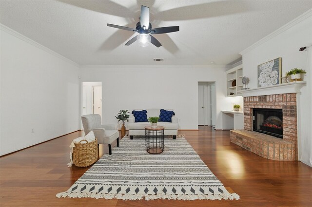 218 Whispering Dell Ln, Weatherford, TX 76085 - living room with crown molding, wood finished floors, a ceiling fan, and a brick fireplace