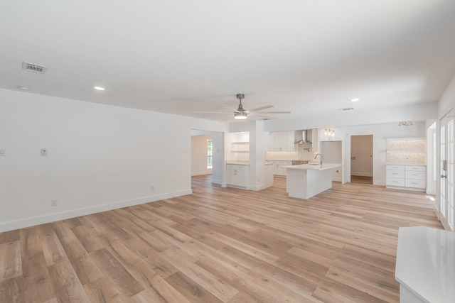 2815 Perkins Rd, Arlington, TX 76016 - unfurnished living room featuring light wood-style flooring, ceiling fan, baseboards, recessed lighting, and a sink