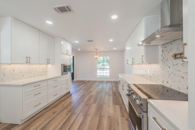 2815 Perkins Rd, Arlington, TX 76016 - kitchen featuring wall chimney exhaust hood, stainless steel range, light wood finished floors, backsplash, and recessed lighting