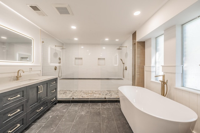 2815 Perkins Rd, Arlington, TX 76016 - bathroom featuring vanity, a tile shower, a freestanding tub, recessed lighting, and tile patterned flooring