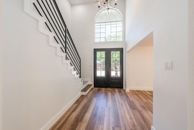 2815 Perkins Rd, Arlington, TX 76016 - foyer entrance with wood finished floors, baseboards, a high ceiling, stairs, and a chandelier