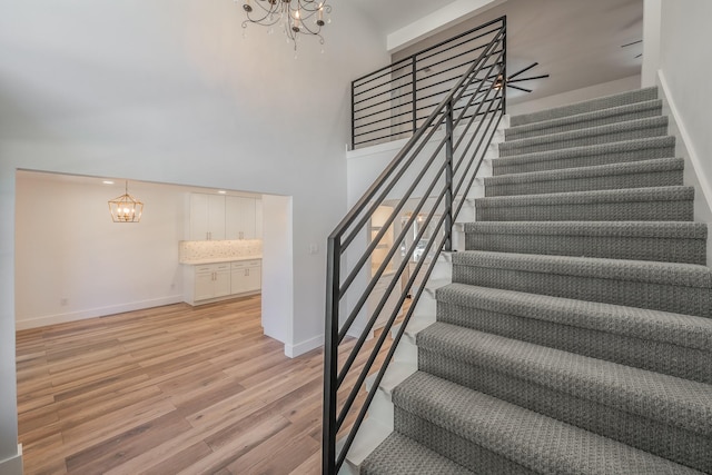 2815 Perkins Rd, Arlington, TX 76016 - staircase featuring a chandelier, wood finished floors, baseboards, and a towering ceiling