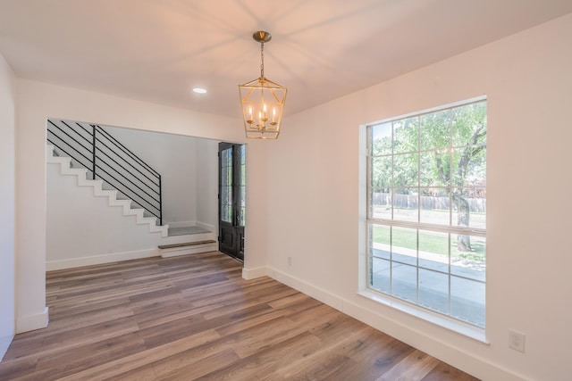 2815 Perkins Rd, Arlington, TX 76016 - unfurnished dining area with a chandelier, light wood-style flooring, baseboards, stairway, and recessed lighting