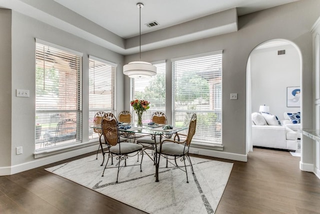 dining area featuring plenty of natural light, baseboards, and arched walkways