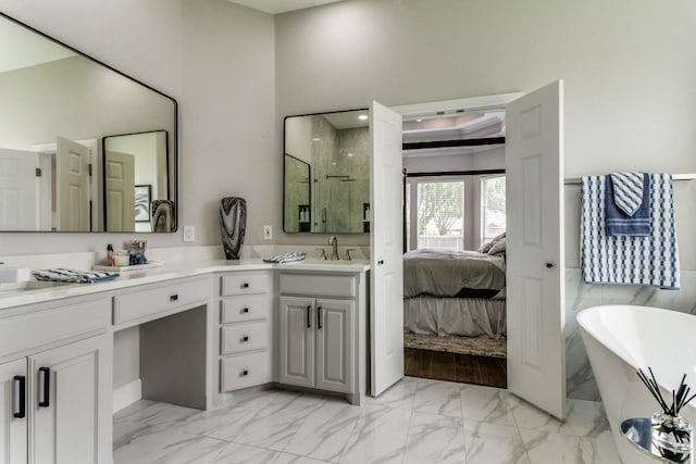 ensuite bathroom with marble finish floors, a stall shower, vanity, and a freestanding bath