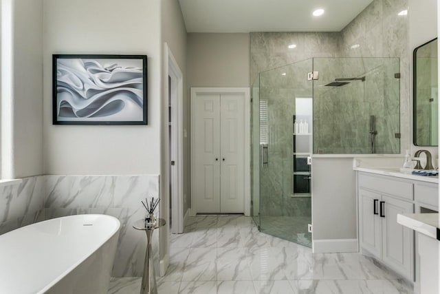bathroom featuring a stall shower, a freestanding bath, vanity, marble finish flooring, and recessed lighting