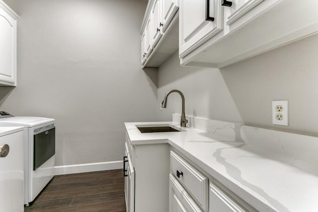 laundry area with washer and clothes dryer, cabinet space, dark wood finished floors, and baseboards