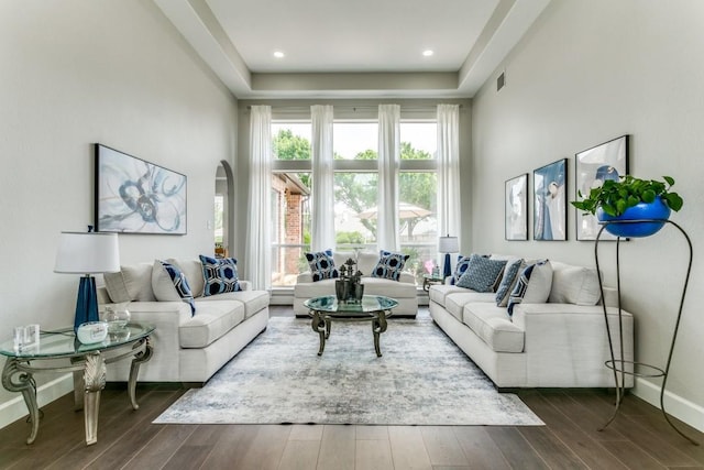 living area featuring healthy amount of natural light, dark wood-style floors, and baseboards