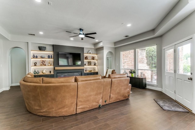 living room with arched walkways, ceiling fan, baseboards, dark wood-type flooring, and recessed lighting