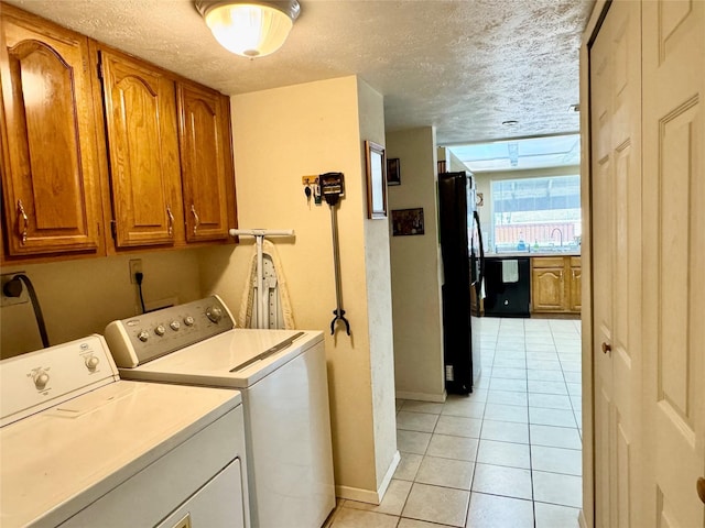 7302 Hardwood Trl, Dallas, TX 75249 - washroom with independent washer and dryer, cabinet space, light tile patterned flooring, baseboards, and a textured ceiling