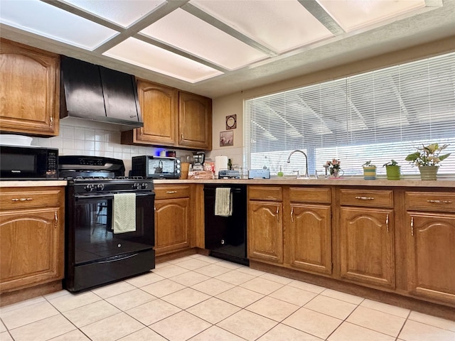 7302 Hardwood Trl, Dallas, TX 75249 - kitchen with black appliances, range hood, light tile patterned floors, brown cabinets, and backsplash