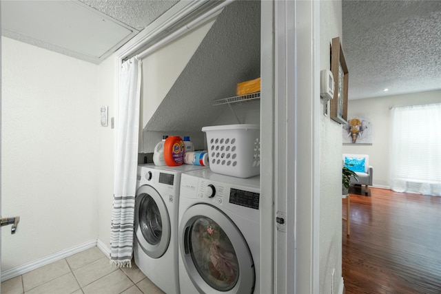 895 Dublin Dr Unit D, Richardson, TX 75080 - laundry area featuring washer and dryer, a textured ceiling, light tile patterned floors, baseboards, and attic access