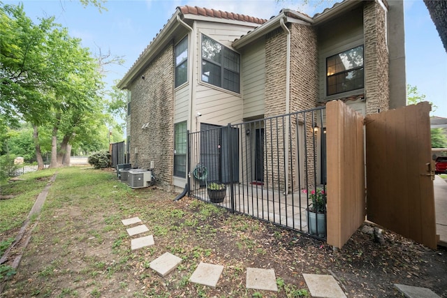 895 Dublin Dr Unit D, Richardson, TX 75080 - back of property with fence, a tile roof, and central AC