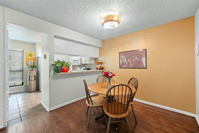 895 Dublin Dr Unit D, Richardson, TX 75080 - dining area featuring a textured ceiling, wood finished floors, baseboards, and a textured wall