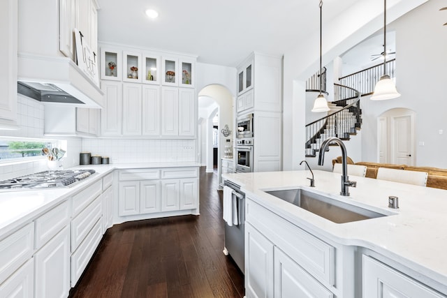 206 Stallion Ln, Hickory Creek, TX 75065 - kitchen with stainless steel appliances, a sink, arched walkways, dark wood-style floors, and light countertops