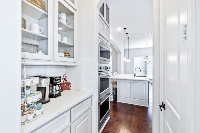 206 Stallion Ln, Hickory Creek, TX 75065 - kitchen featuring appliances with stainless steel finishes, white cabinets, dark wood-type flooring, glass insert cabinets, and hanging light fixtures
