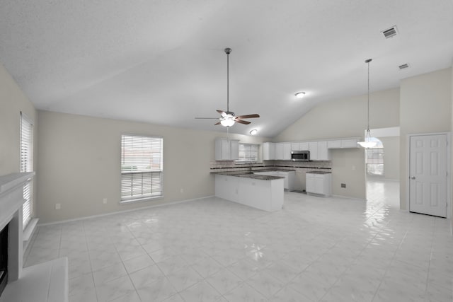 7816 Teal Dr, Fort Worth, TX 76137 - unfurnished living room featuring ceiling fan, a fireplace, baseboards, and high vaulted ceiling