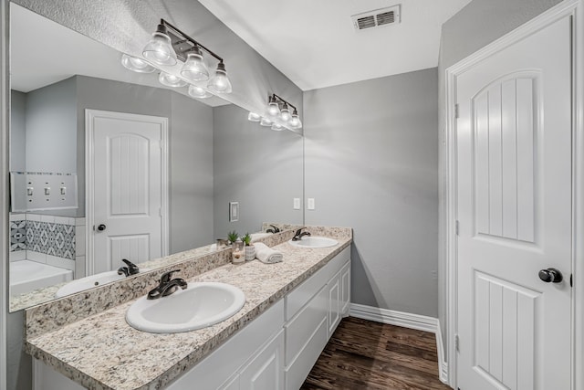 160 Grays Creek Cir, Alma, TX 75119 - bathroom featuring wood finished floors, baseboards, and double vanity
