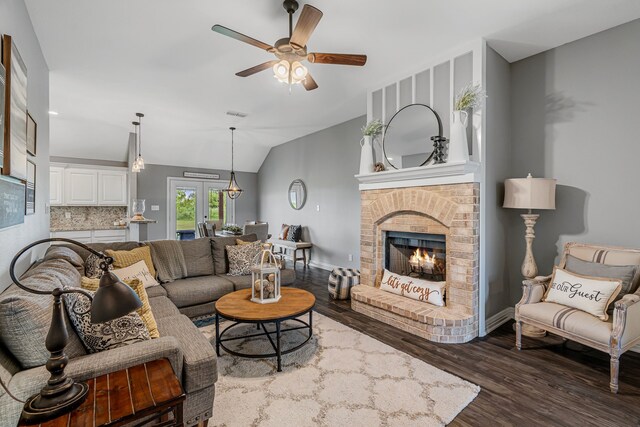 160 Grays Creek Cir, Alma, TX 75119 - living area featuring ceiling fan, wood finished floors, lofted ceiling, a brick fireplace, and baseboards