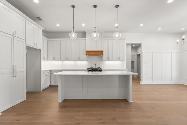 14572 Woodland Creed Dr, Tyler, TX 75706 - kitchen with light countertops, tasteful backsplash, light wood-style floors, white cabinets, and recessed lighting