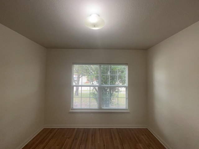 10009 Iron Ridge Dr, Fort Worth, TX 76140 - unfurnished room featuring dark wood-style flooring, baseboards, and a textured ceiling