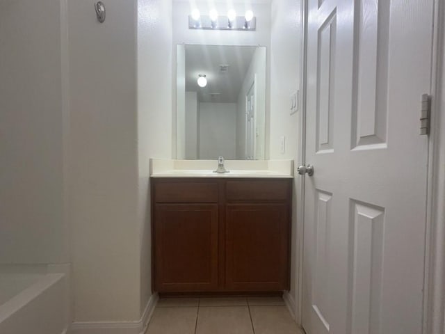10009 Iron Ridge Dr, Fort Worth, TX 76140 - bathroom with tile patterned floors, vanity, baseboards, and a bathtub