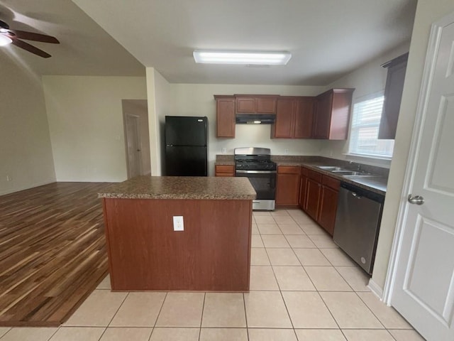 10009 Iron Ridge Dr, Fort Worth, TX 76140 - kitchen featuring stainless steel appliances, under cabinet range hood, dark countertops, and a sink