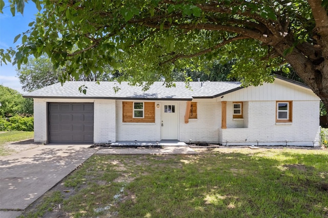 single story home with brick siding, an attached garage, driveway, and a front yard